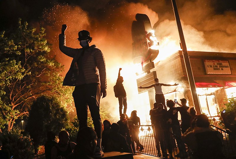Minneapolis protestors outside of a burning Arby’s