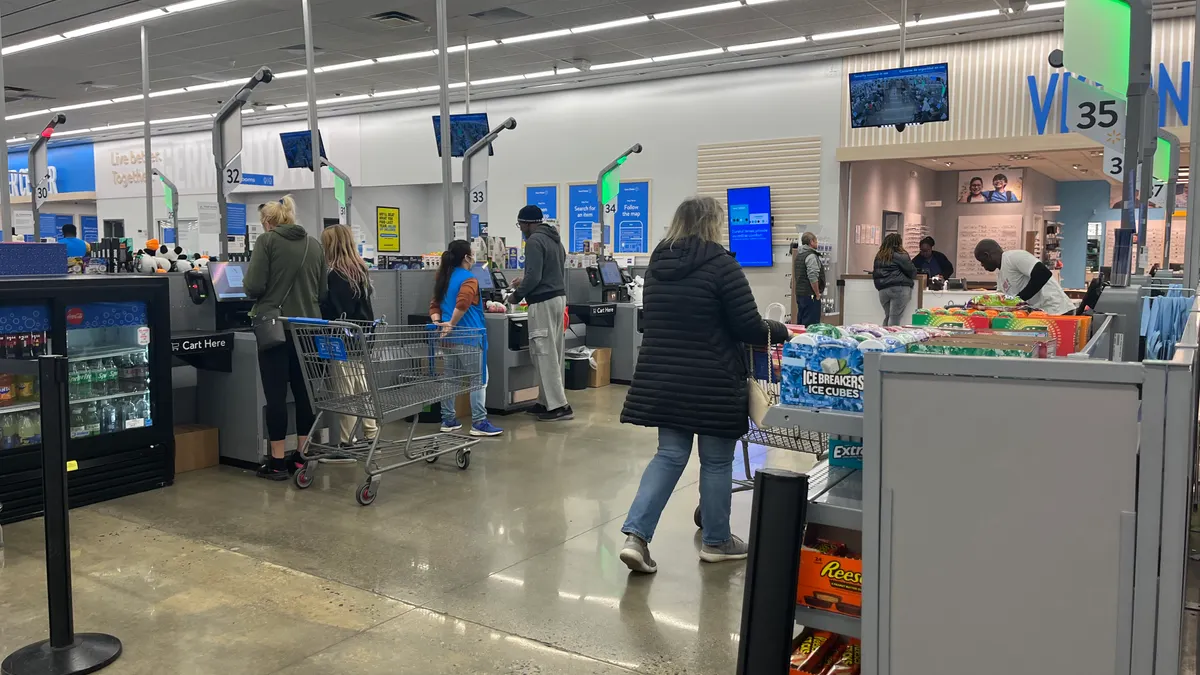Walmart customers checkout at self-service kiosks.