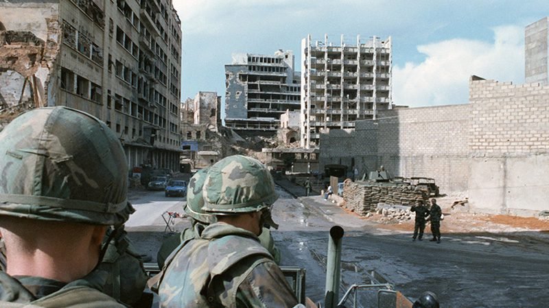 Beirut during the Lebanese Civil War 1975-1990, with destroyed buildings and armed conflict between Christian and Muslim factions.