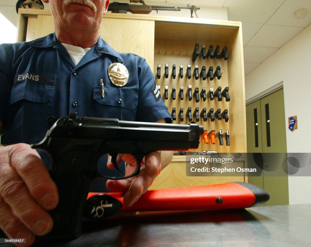 Armory officer Ron Evans holds a Beretta 92F 9mm pistol.